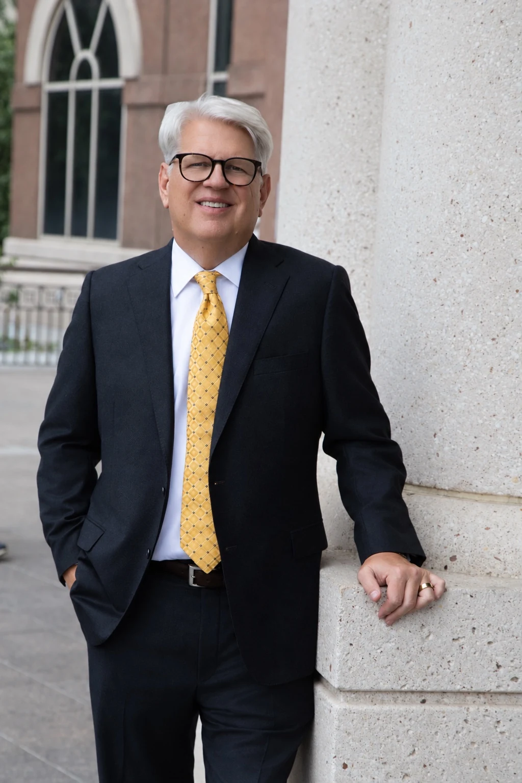 Byron K. Barclay standing by a stone column
